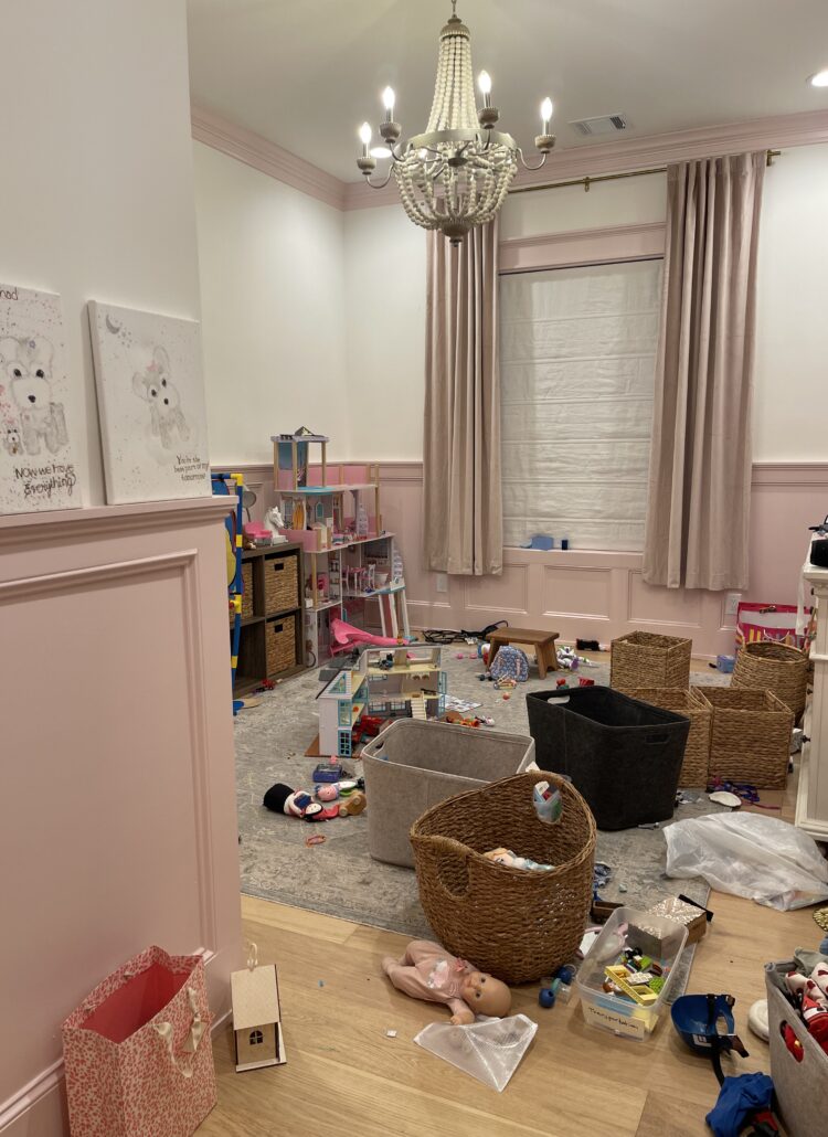A child's bedroom floor covered in scattered toys and empty bins