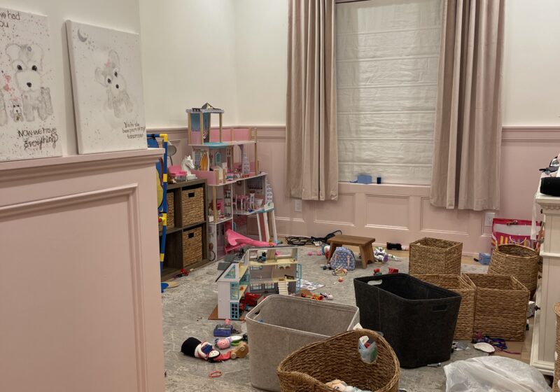 A child's bedroom floor covered in scattered toys and empty bins